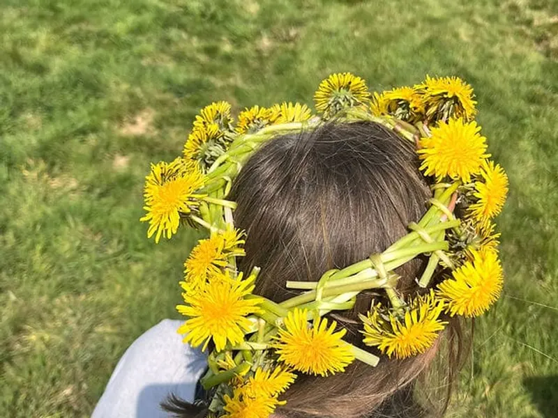 Child wearing a dandelion crown at Maypole Farm — creativity and joy in outdoor learning